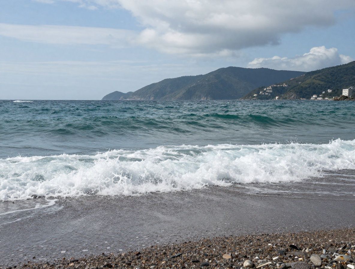 Gouttes d'huile d'argan dorée tombant dans un bol en céramique blanche entouré de graines d'argan brunes sur fond naturel texturé